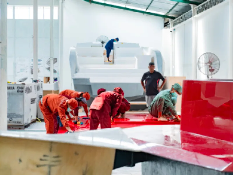 Workers building a boat inside the Fortune Yachts facility